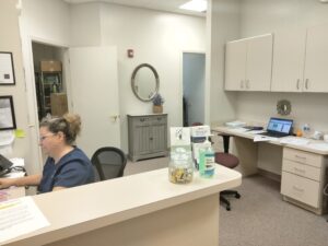 The check-in area of Pinnacle Wellness Group with the receptionist seated at her desk